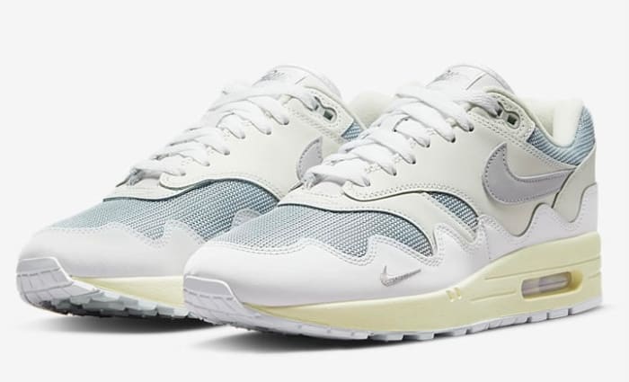 View of white and grey Nike Air Max 1 shoes.